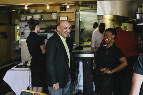 Qayum Karzai, the older brother of Afghanistan's longtime president Hamid Karzai, talks to staff at one of three restaurants he and his family own in Baltimore. (Greg Kahn for The Wall Street Journal)