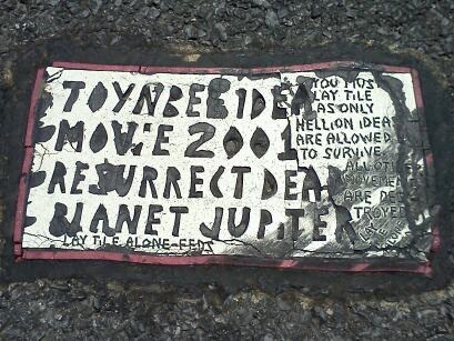 Toynbee Tile in middle of Centre Street at intersection of Centre & Calvert.